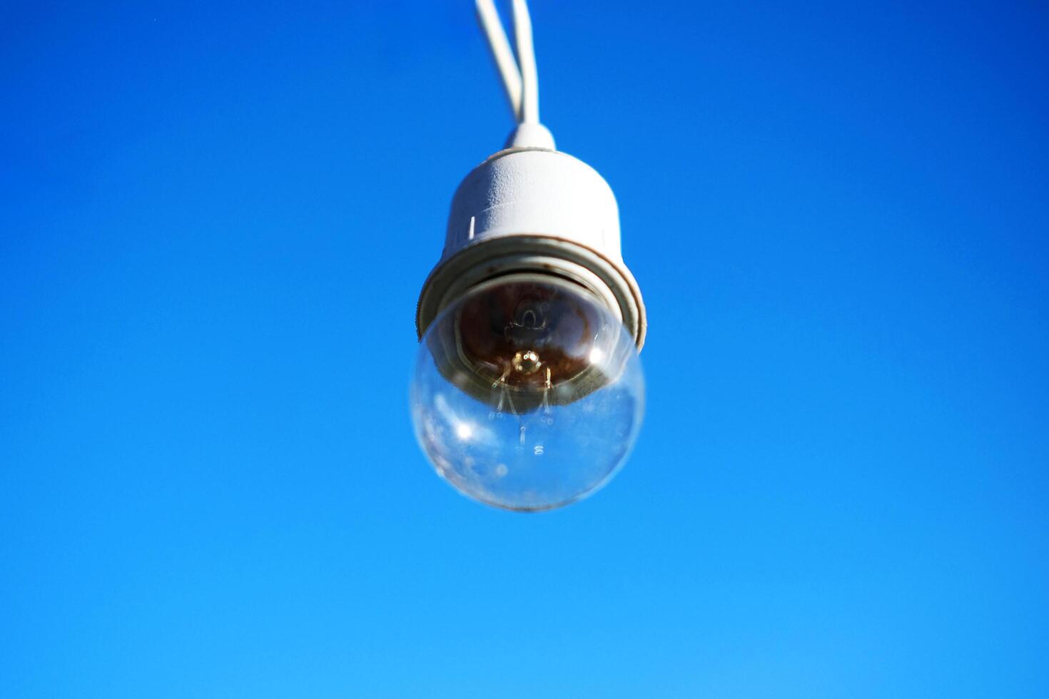 Equipped and electrical with light bulbs is hanging in the wind and sunlight on blue sky photo