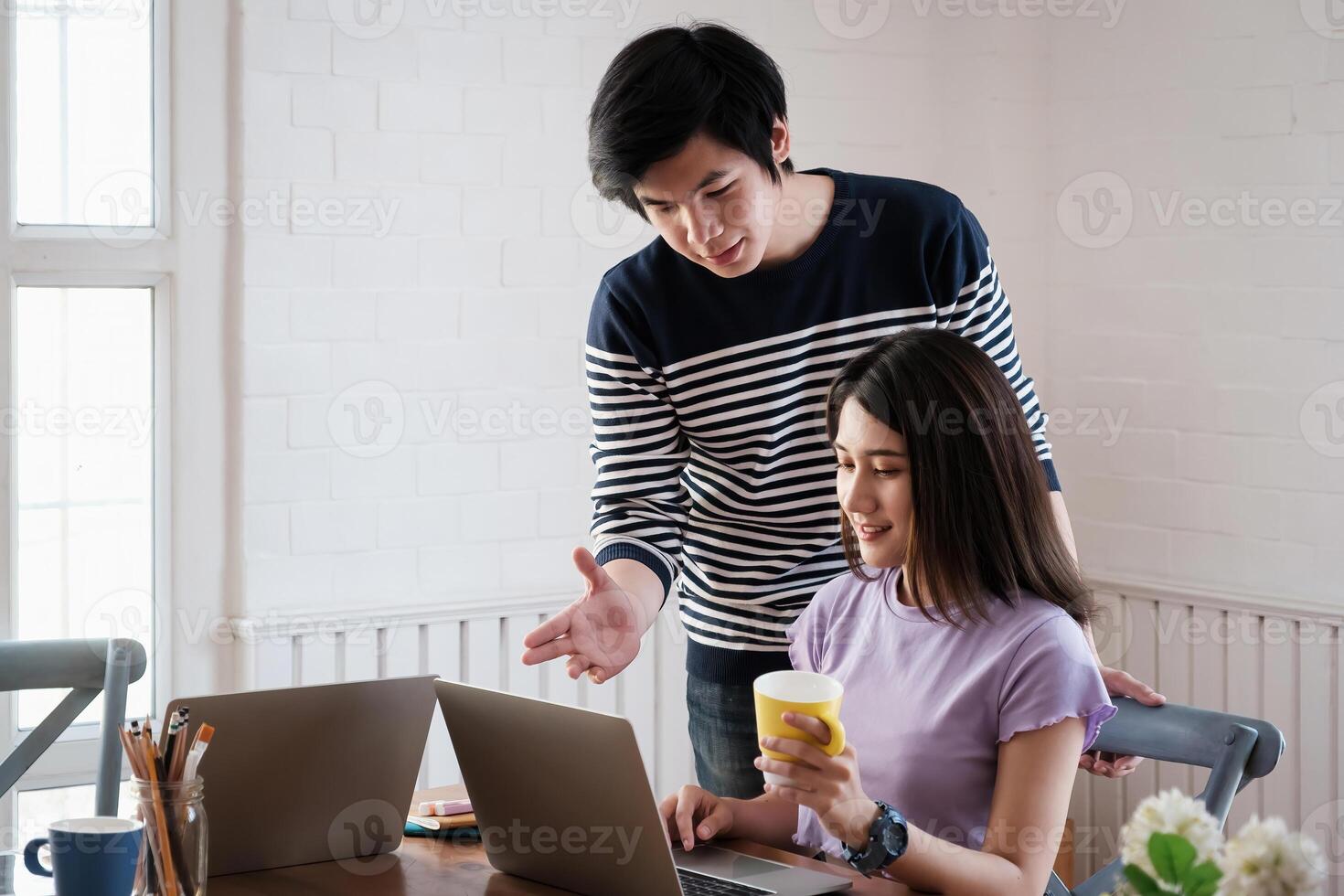 Young university man help friend tutorial math, physics before exam in living room by online class in laptop computer. photo