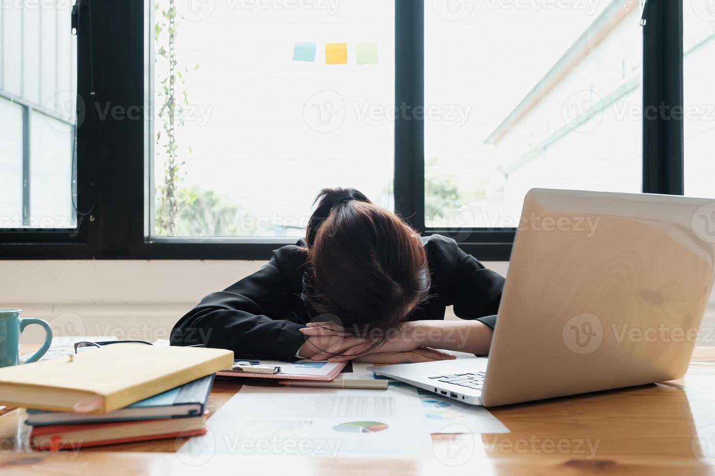 Stressed business woman hard working until morning and tired and sleep at table in office while project deadlines. finance, account, tax, audit concept. photo