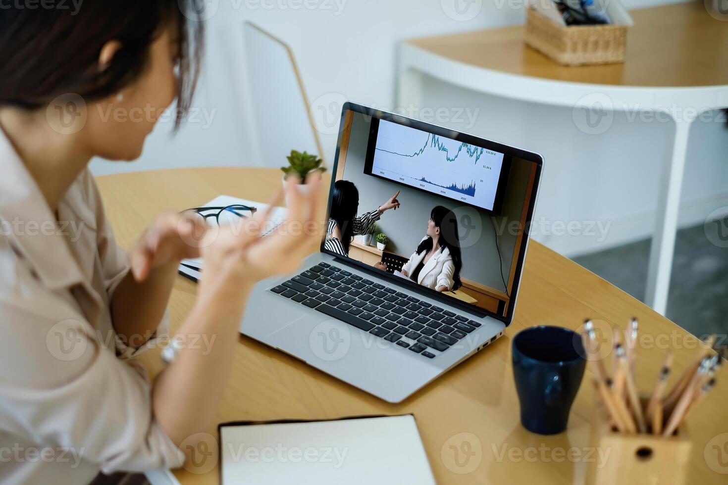 Rear view of female employee meeting via call with employee brief the stock market chart. photo