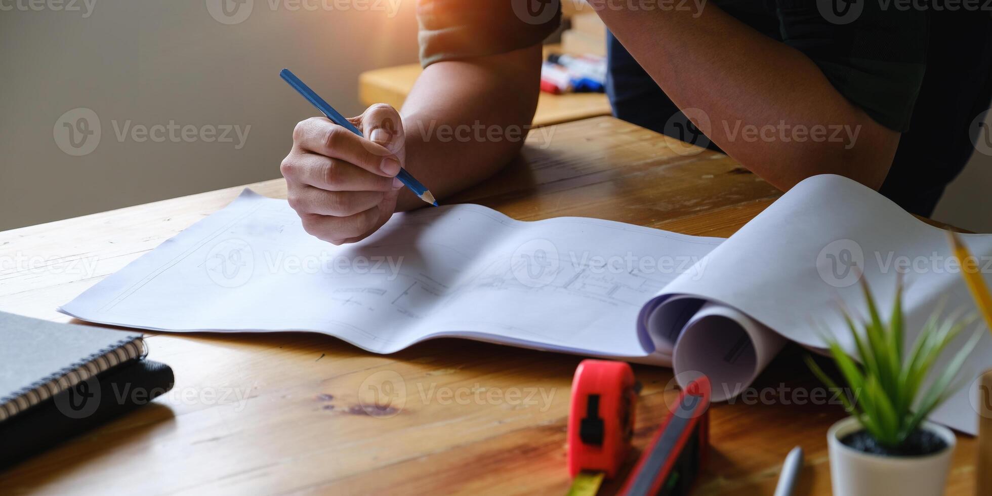 Business engineer hand holding pencil with construction drawing. consulting planning for engineering concept. photo