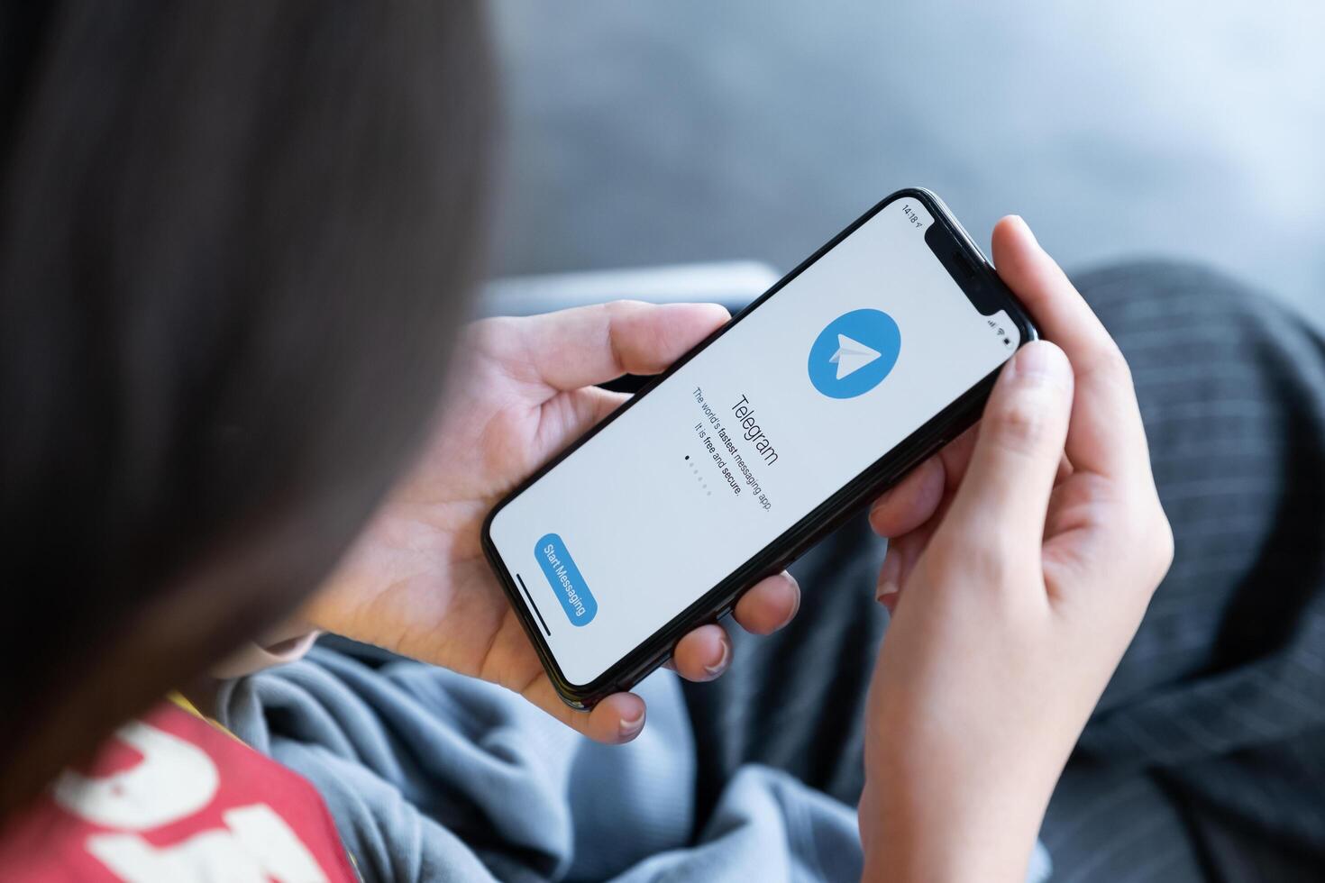 CHIANG MAI, THAILAND, MAR 03, 2021 . Woman hand holding iPhone X with social networking service Telegram on the screen. iPhone 10 was created and developed by the Apple inc. photo