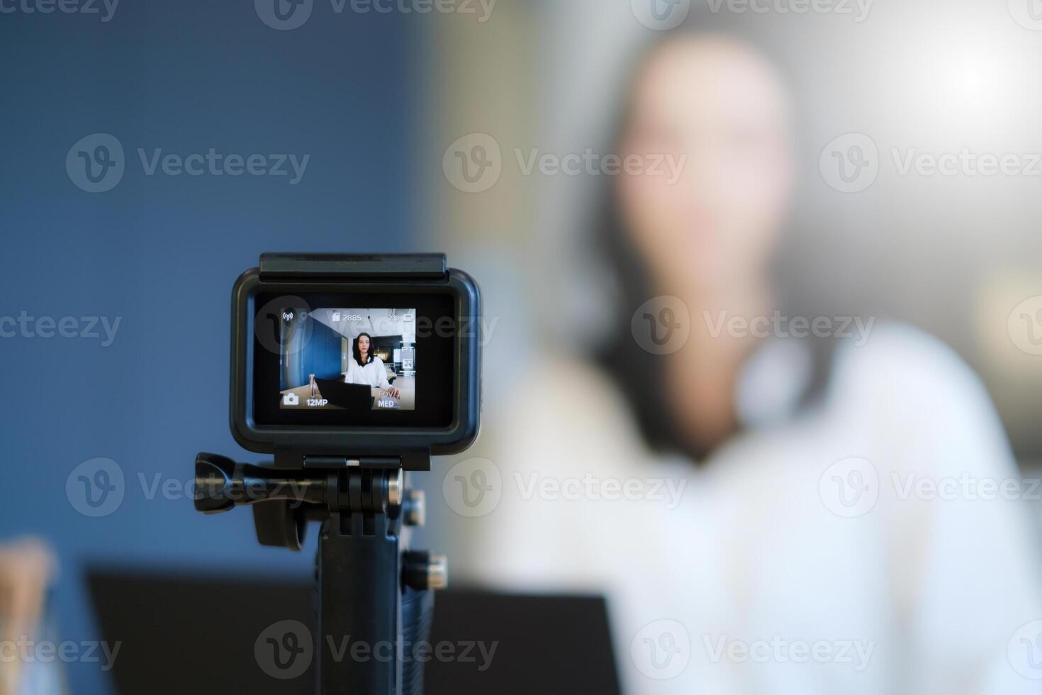 Business woman or blogger recording vlog on digital camera and live stream. photo