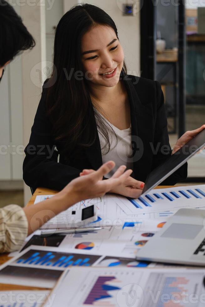 For the investigation of a corruption account, a group of businesswomen and accountants search data documents on a laptop. definition of anti-bribery. photo