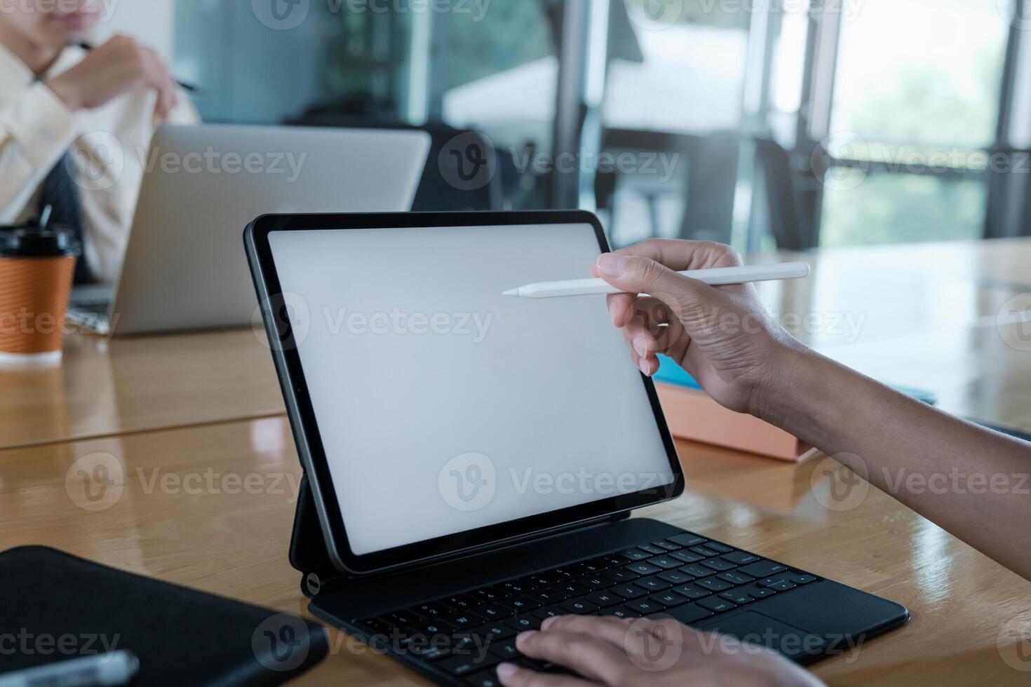 Close up hand of businesswoman with digital tablet with blank screen on wooden desk. photo