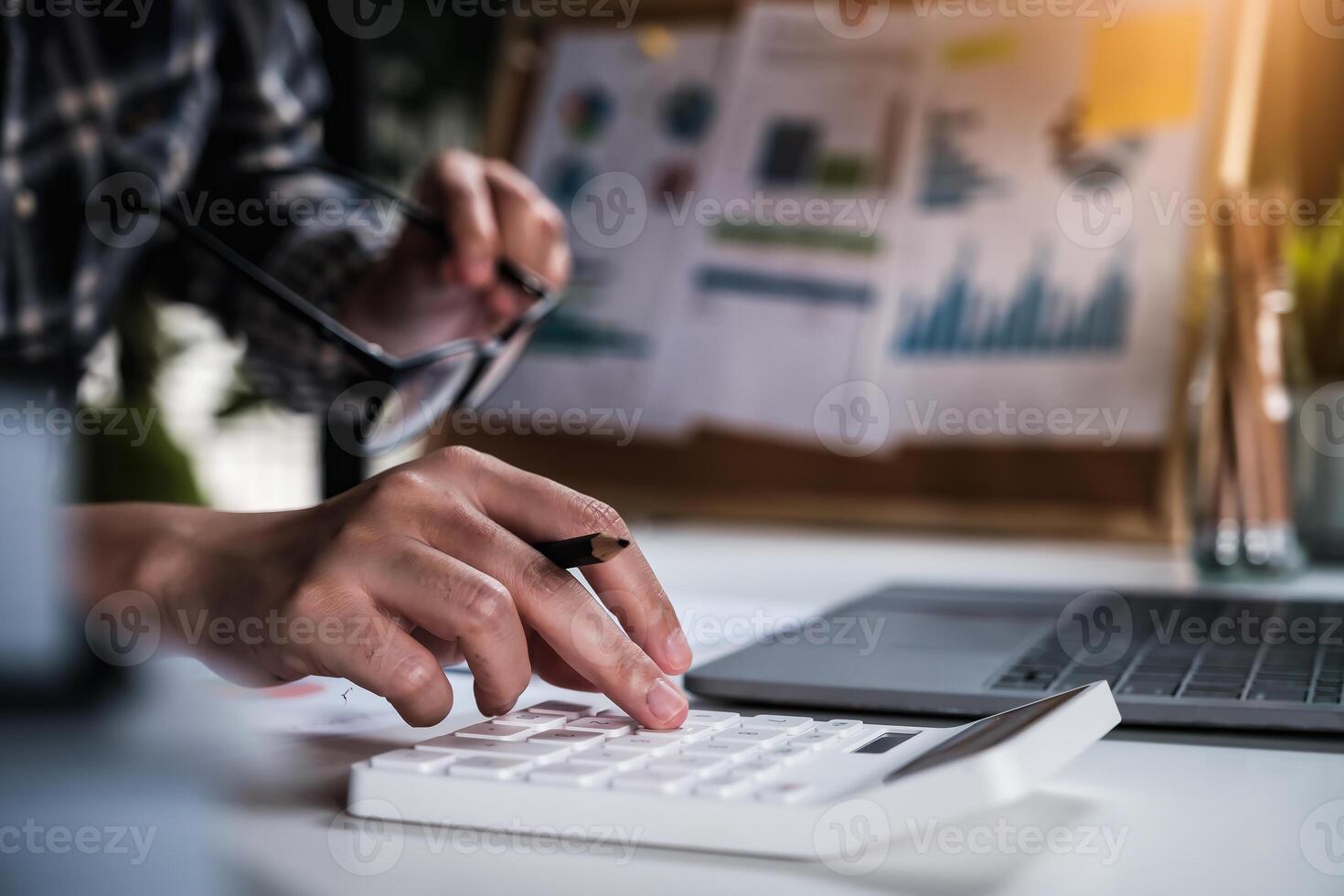 Project management updating and calculating financial chart on paperwork. work from home concept. photo