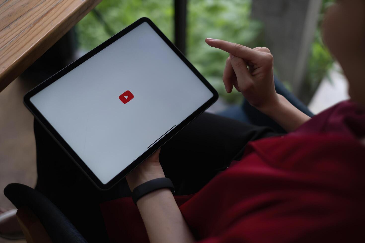 Chiang mai, Thailand - AUG 09, 2021 . Woman using a tablet to connect to YouTube Premium. YouTube is a video-sharing website by google photo