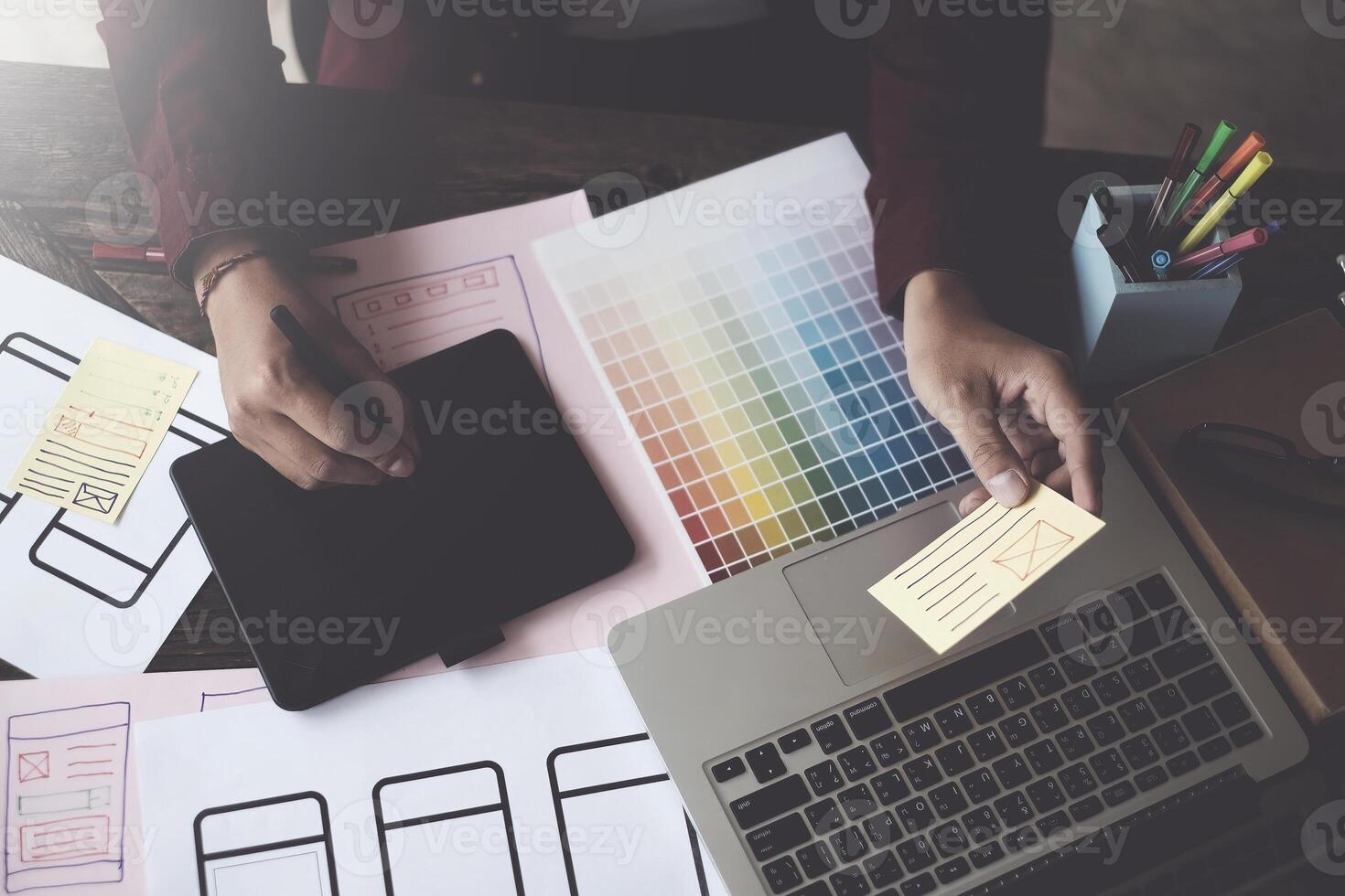 Until creating a mobile application, a developer compares color and interface wireframes photo