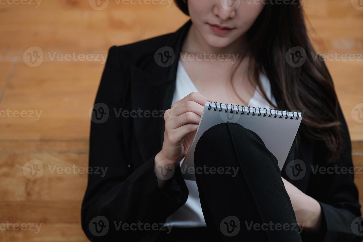 Cropped image of a businesswoman jotting down ideas on a notepad photo