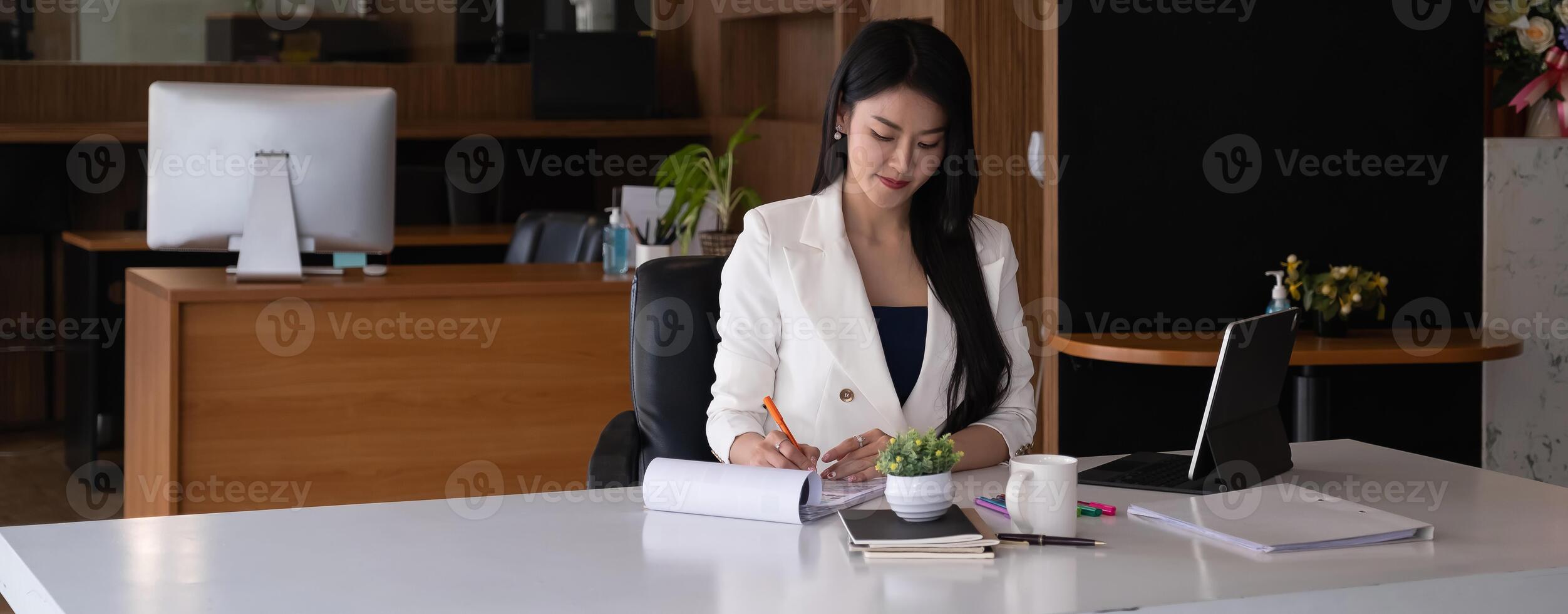 Business woman reading minute of meeting on her notebook in office. photo