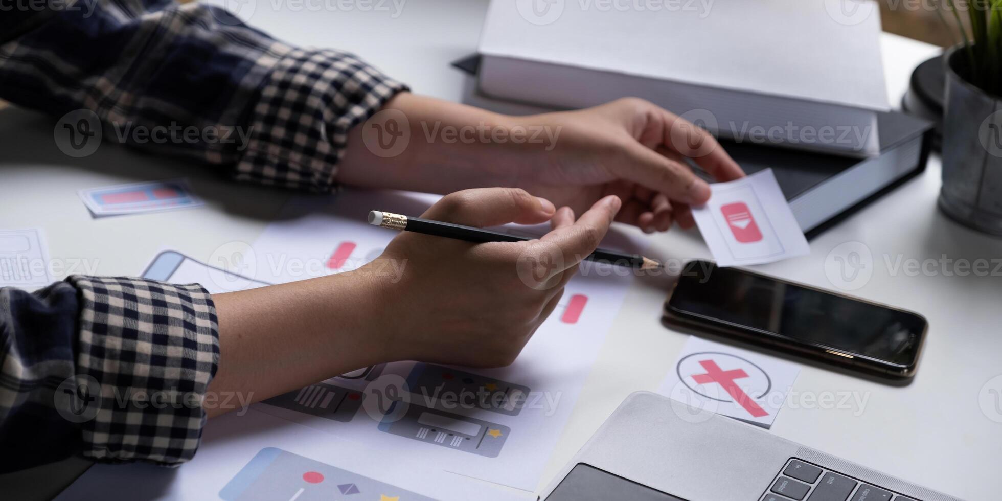 A close-up of an ux ui developer and an ui designer working on a mockup icon interface for a mobile app. photo