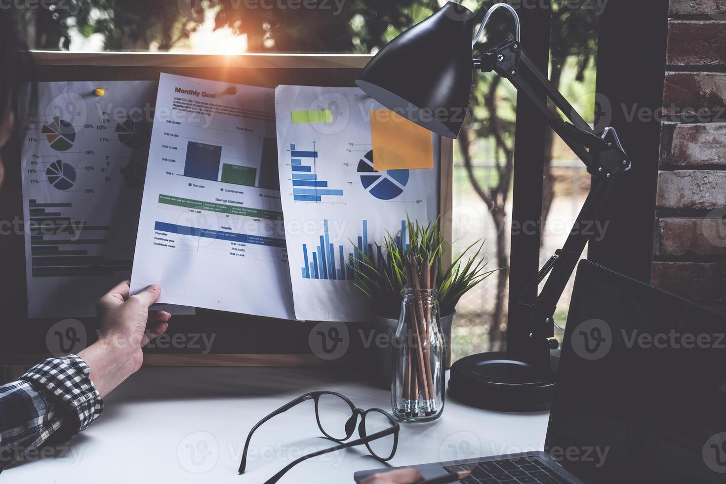 Project management updating financial chart with paperwork on board, work from home concept. photo