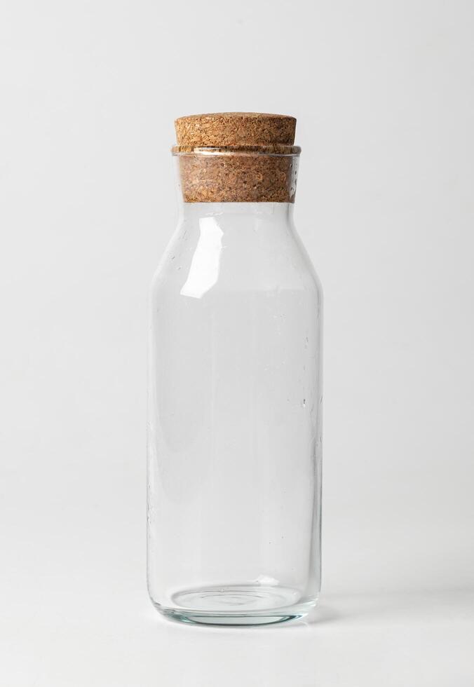 Empty glass jar with brown corke isolated on white background photo