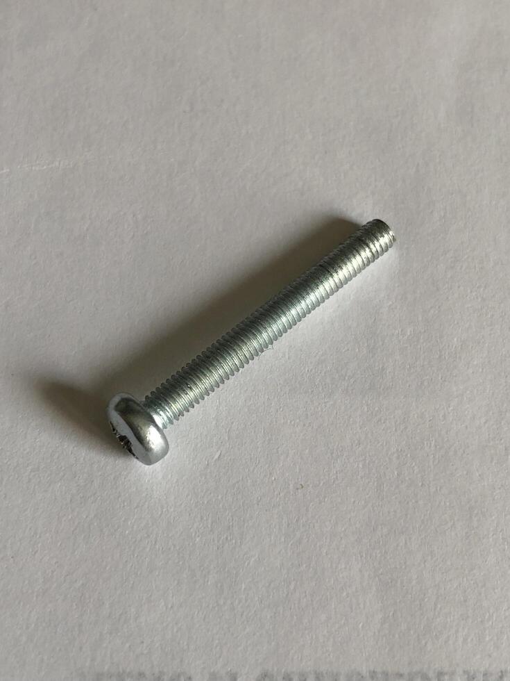 Full thread screw with convex head on white background photo