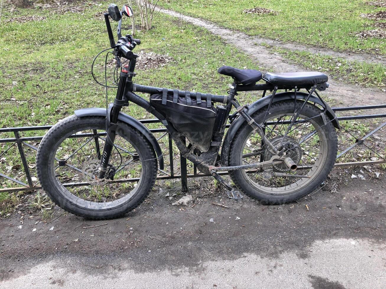 poderoso eléctrico bicicleta con grande grueso ruedas en la carretera polvo en el estacionamiento lote foto