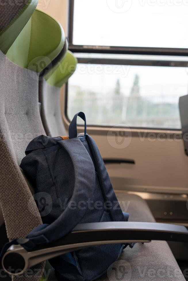 The backpack is on the seat, travel concept. A blue backpack is lying on the seat of a passenger train. Travel to Germany. photo