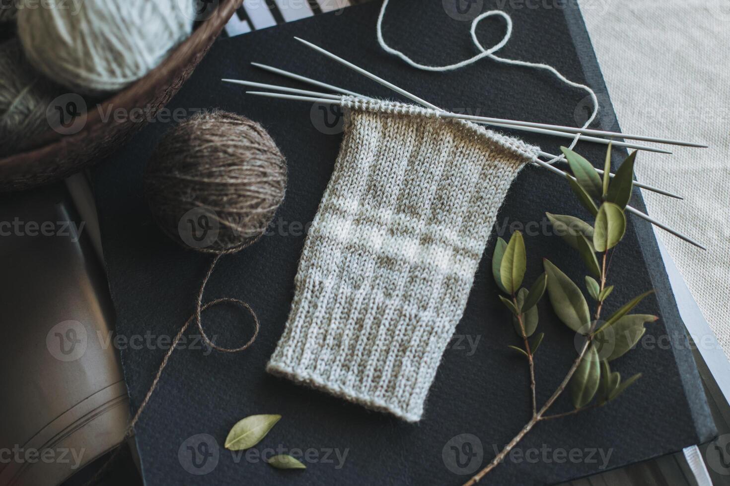 Hand knitted socks with needles and yarn balls. Concept for handmade and hygge slow life. photo