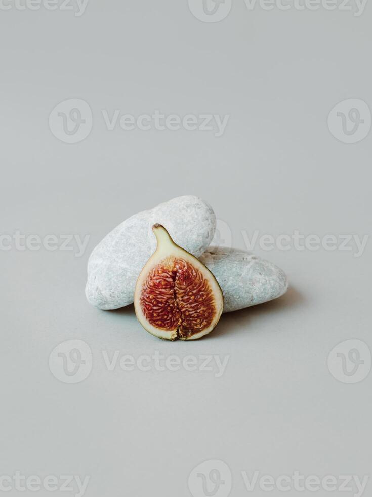 Ripe fig with stones on a grey background. Minimal concept. photo