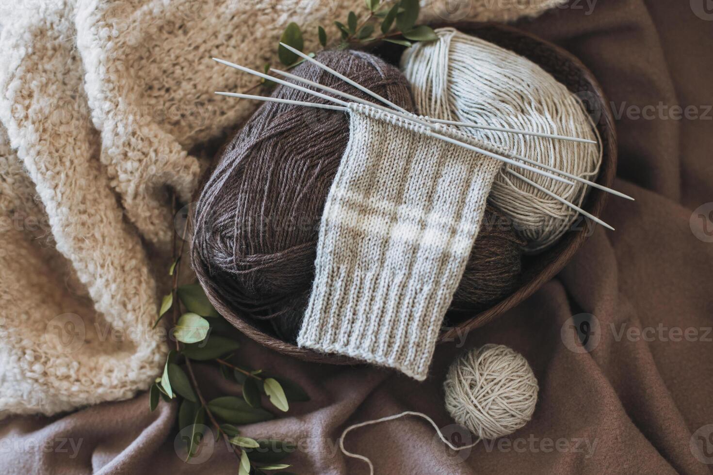 Hand knitted socks with needles and yarn ball in a basket. Concept for handmade and hygge slow life. photo