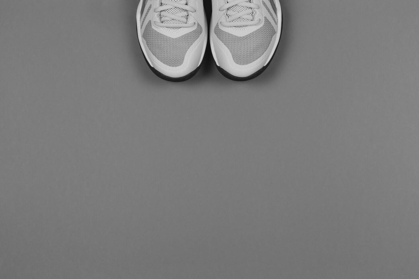 Light grey sneakers on the grey background. Concept for healthy lifestyle and everyday training. photo