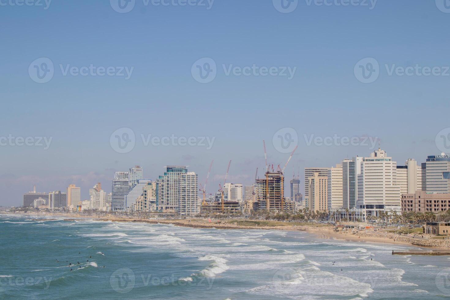 Panoramic View of Tel-Aviv Coastline with City Skyline and Waves Crashing on the Beach photo