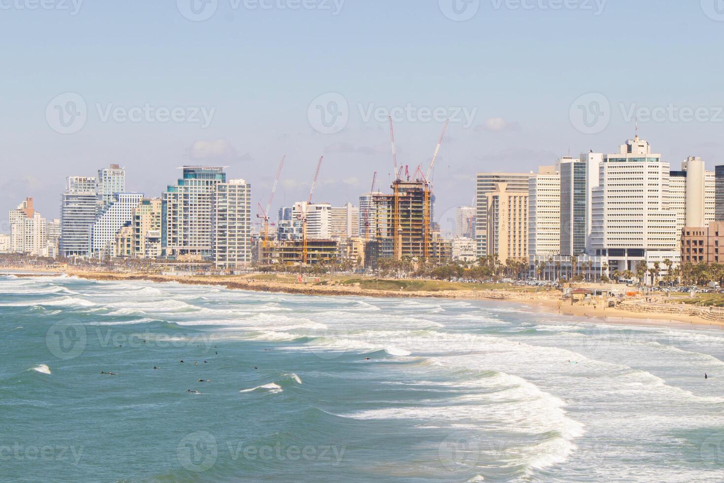 Panoramic View of Tel-Aviv Coastline with City Skyline and Waves Crashing on the Beach photo