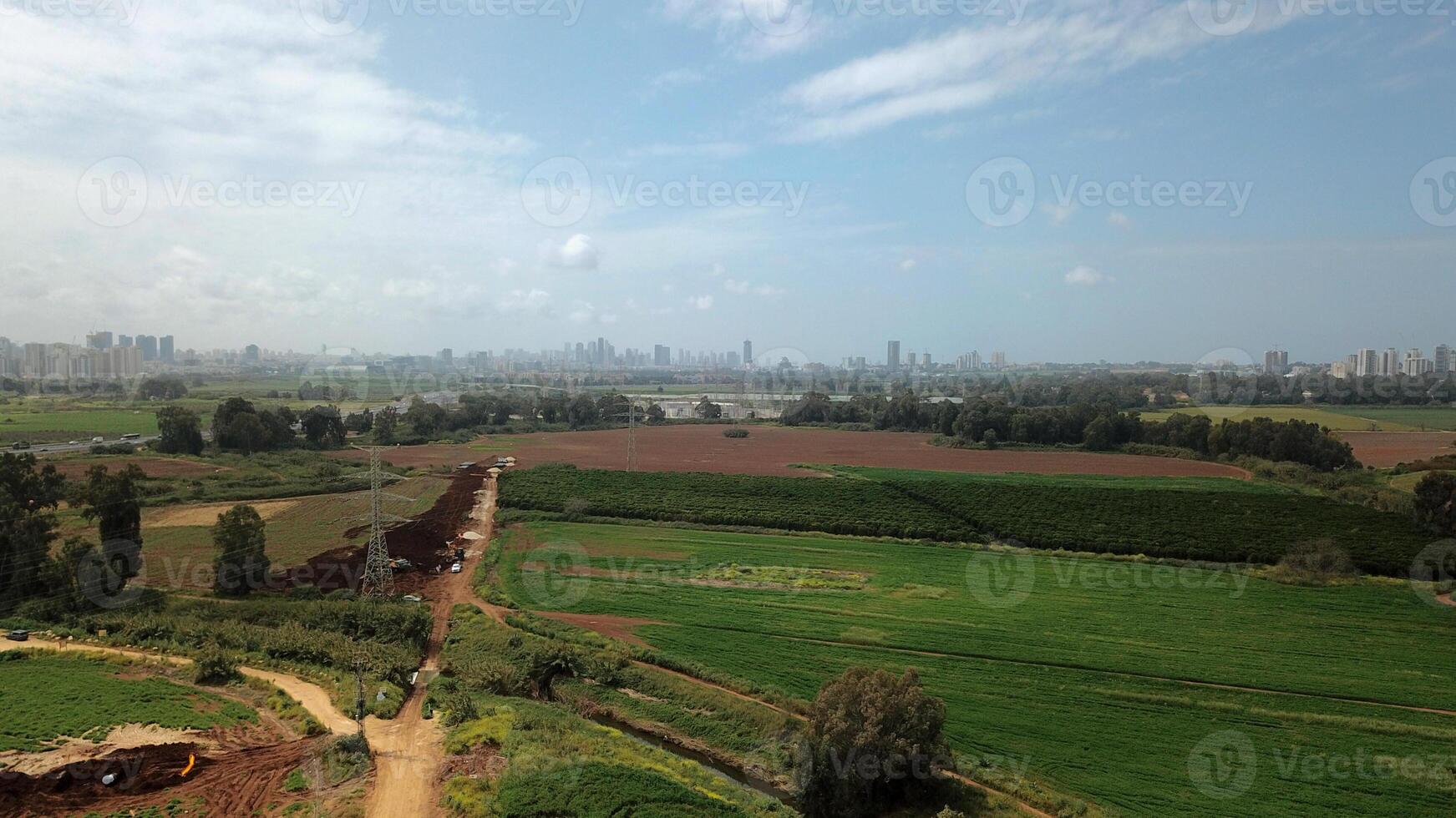 Agricultural Green field aerial view with city skyline in the background photo