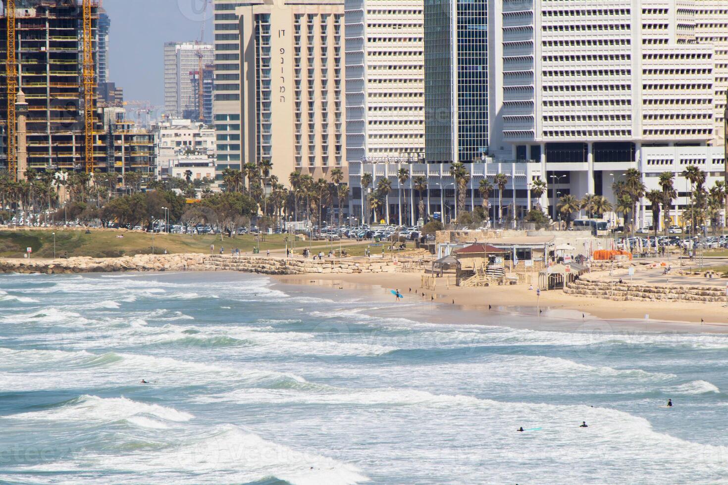 Panoramic View of Tel-Aviv Coastline with City Skyline and Waves Crashing on the Beach photo