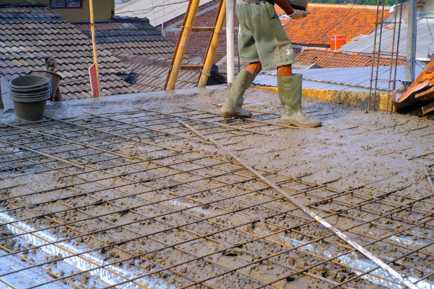 Industrial Photography. Construction work activities. A worker is pouring cement into wire mesh during the floor pouring process. Bandung - Indonesia, Asia photo