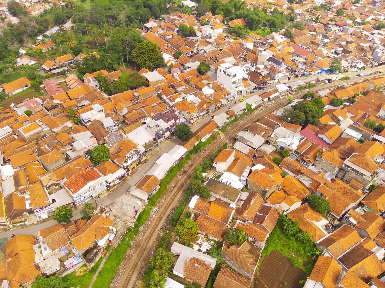 Amazing landscape of Train Tracks. Bird's eye view from drone of a railway line in the middle of densely populated houses in Cicalengka, Indonesia. Shot from a drone flying 200 meters high. photo