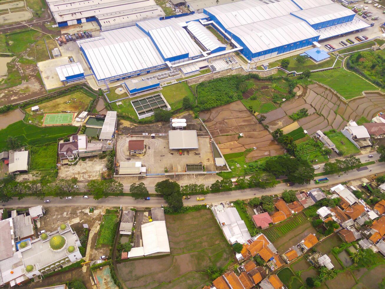 Snack Factory on the outskirts of town. Aerial view of factory in mountain valley, Bandung - Indonesia. Food Industry. Above. Aerial Landscapes. Shot from a drone. photo