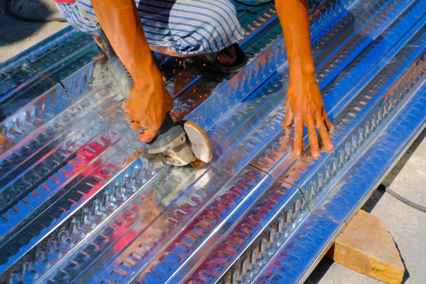 Industrial Photography. Construction works. Photo of a worker's hands cutting a metal deck. Cutting metal deck using a grinder. Bandung - Indonesia, Asia