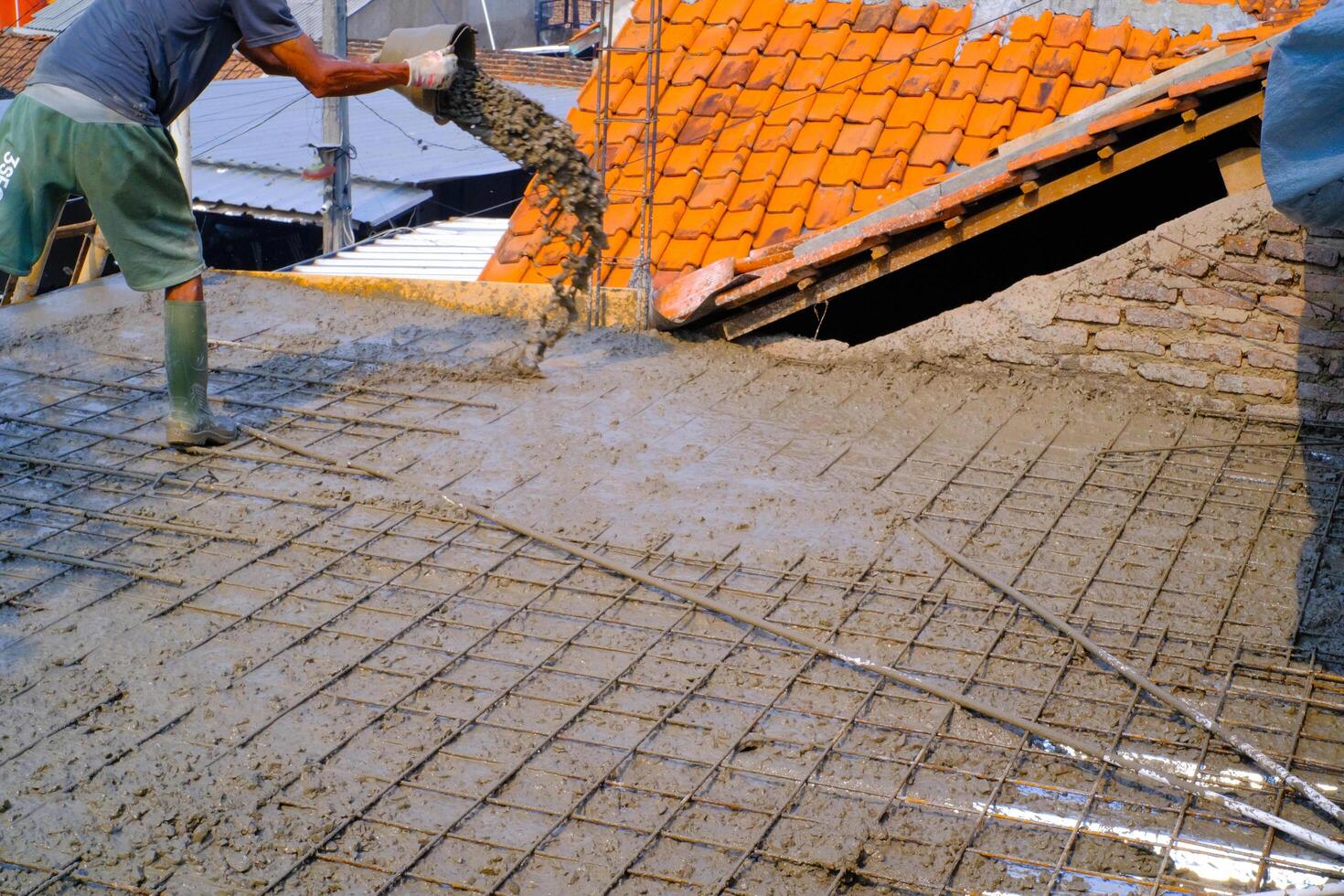 Industrial Photography. Construction work activities. A worker is pouring cement into wire mesh during the floor pouring process. Bandung - Indonesia, Asia photo