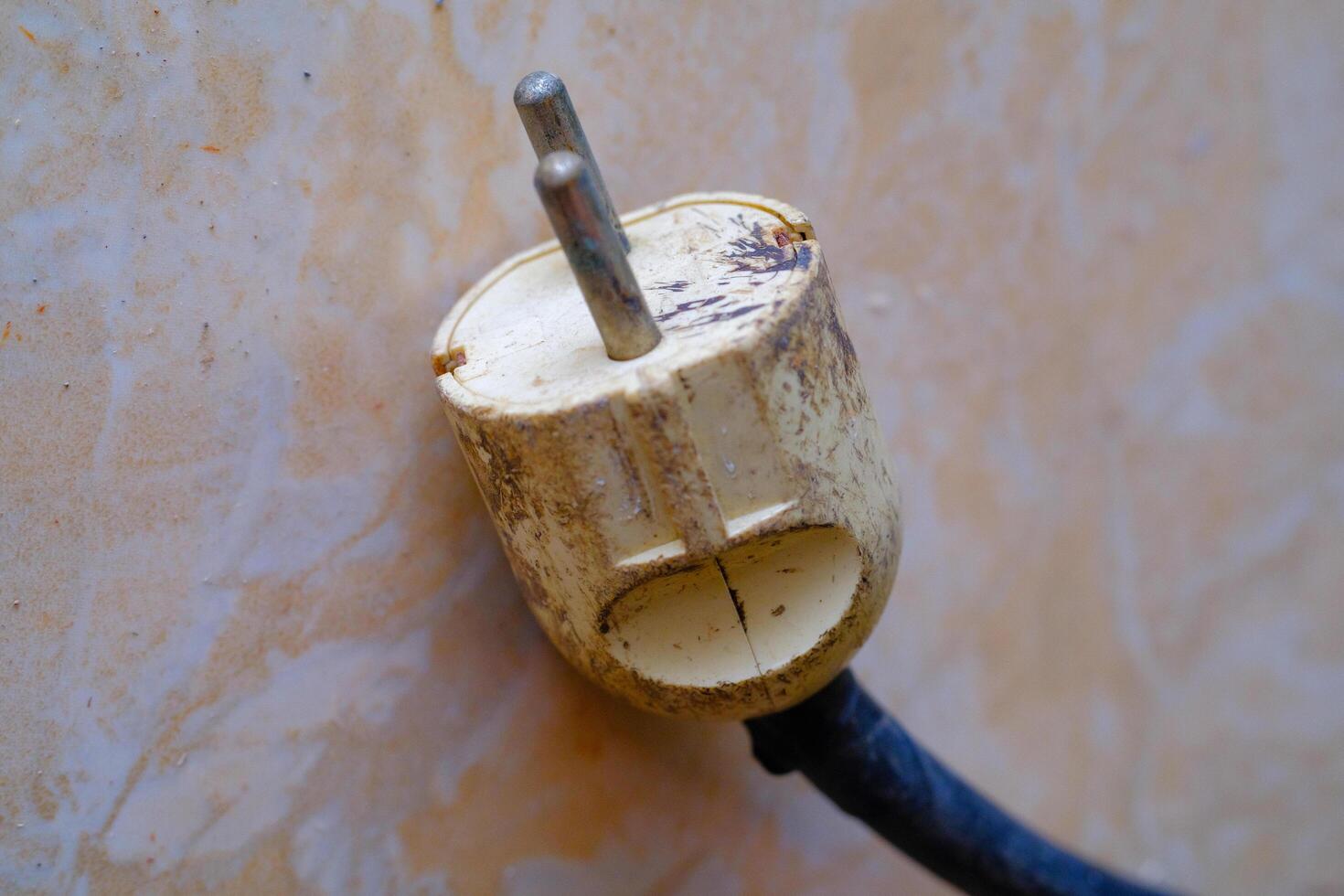 Industrial Photography. Construction Tools. Isolated worn electric plug with blue wire. A cable plug on the floor. Bandung, Indonesia photo