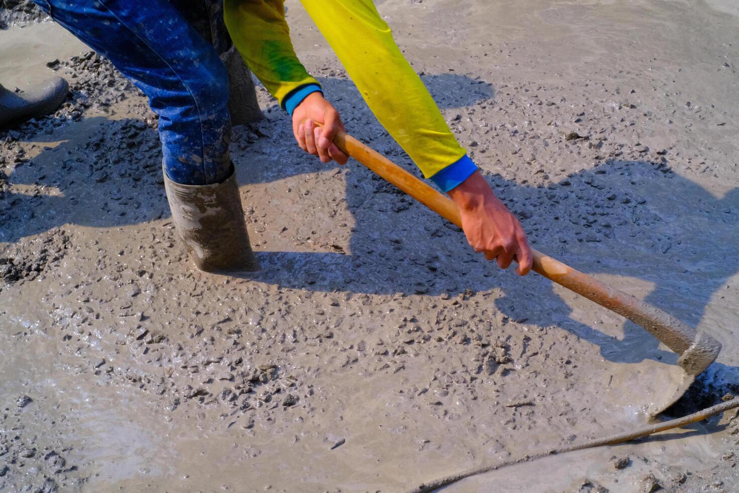 ndustrial Photography. Construction work activities. Workers are hoeing and mixing cement with sand and stones for cement castings. Bandung - Indonesia, Asia photo