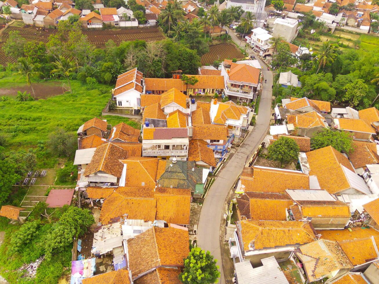 Bird's eye view from drone of a railroad track between residential areas and rice fields in Cicalengka, Indonesia. Shot from a drone flying 200 meters high photo