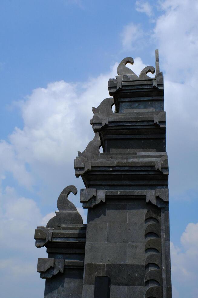 Architectural Photography. Architectural Beauty. View of the gate with a typical Balinese architectural style. Gate with view of cloudy blue sky. Bandung, Indonesia photo