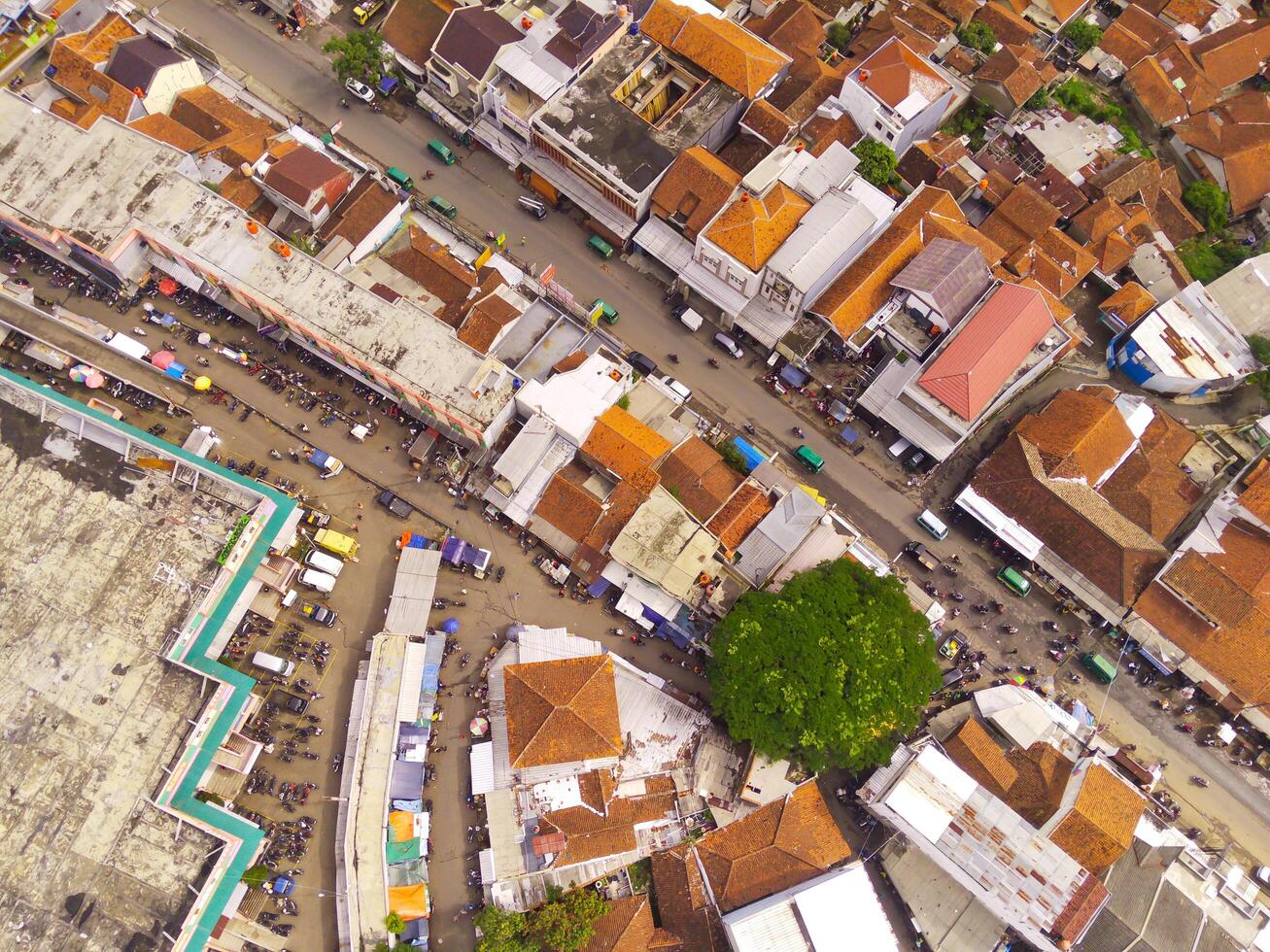 Aerial view of Main street of West Java Province, Indonesia. The main road in the middle of residential areas. Motorbikes, cars and electric vehicles traffic on the main road. Shot from a drone flying photo