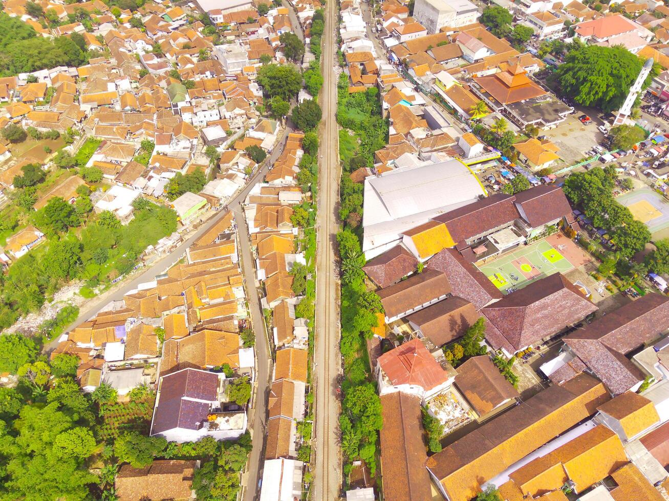 Amazing landscape of Train Tracks. Bird's eye view from drone of a railway line in the middle of densely populated houses in Cicalengka, Indonesia. Shot from a drone flying 200 meters high. photo