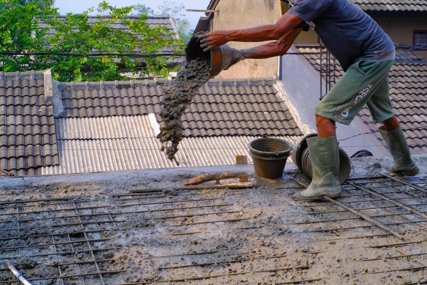 Industrial Photography. Construction work activities. A worker is pouring cement into wire mesh during the floor pouring process. Bandung - Indonesia, Asia photo