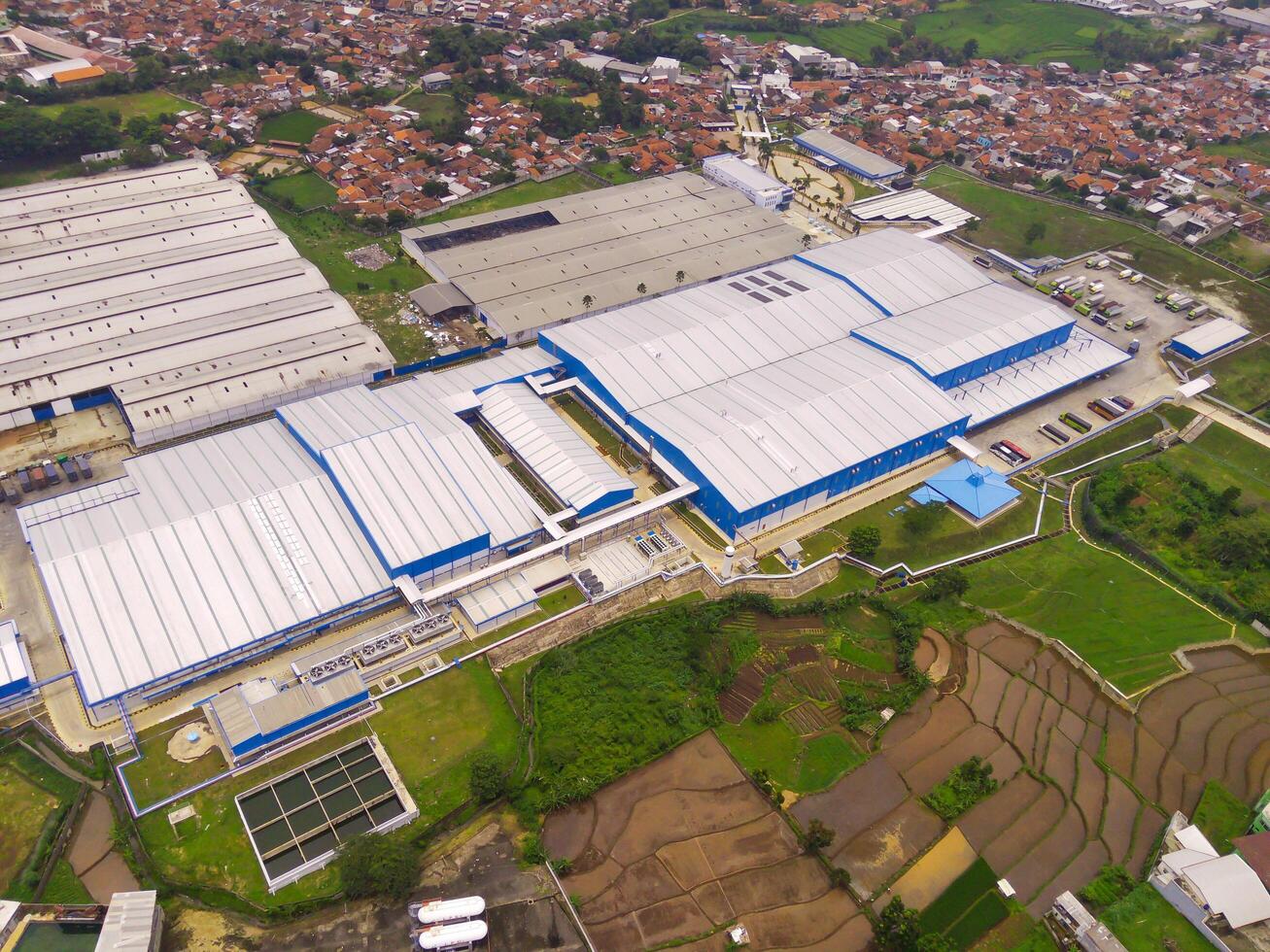 Snack Factory on the outskirts of town. Aerial view of factory in mountain valley, Bandung - Indonesia. Food Industry. Above. Aerial Landscapes. Shot from a drone. photo