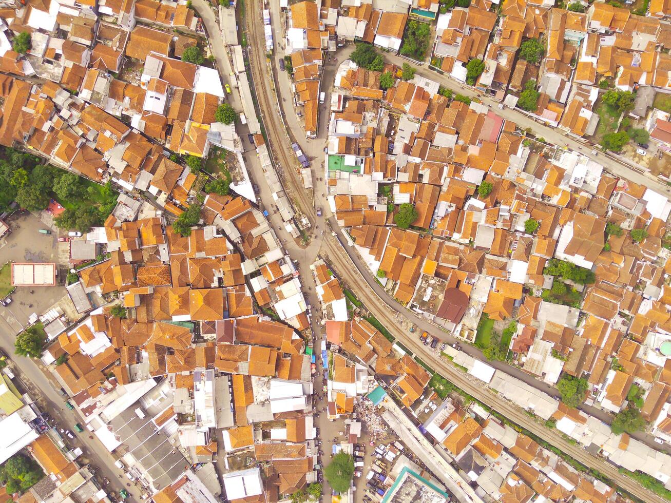 Amazing landscape of Train Tracks. Bird's eye view from drone of a railway line in the middle of densely populated houses in Cicalengka, Indonesia. Shot from a drone flying 200 meters high. photo