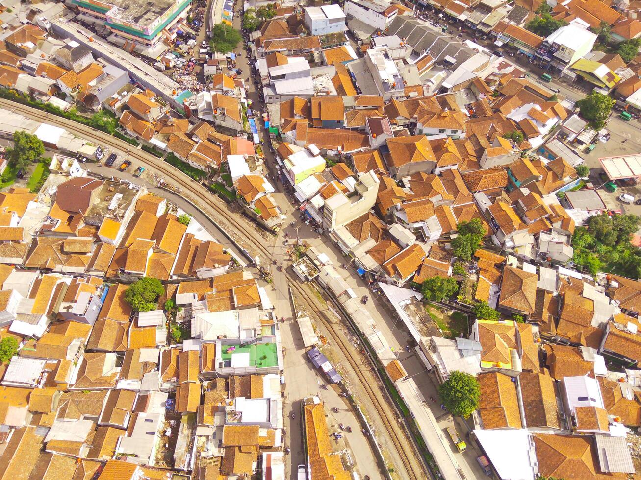 Amazing landscape of Train Tracks. Bird's eye view from drone of a railway line in the middle of densely populated houses in Cicalengka, Indonesia. Shot from a drone flying 200 meters high. photo