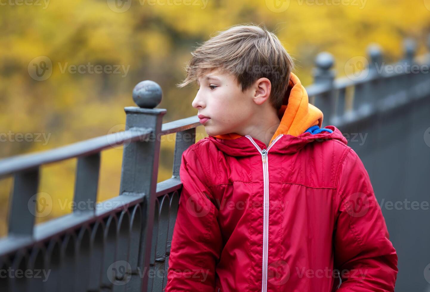 A thoughtful teenage boy walks outside, looks around. Psychological portrait of a teenager. photo