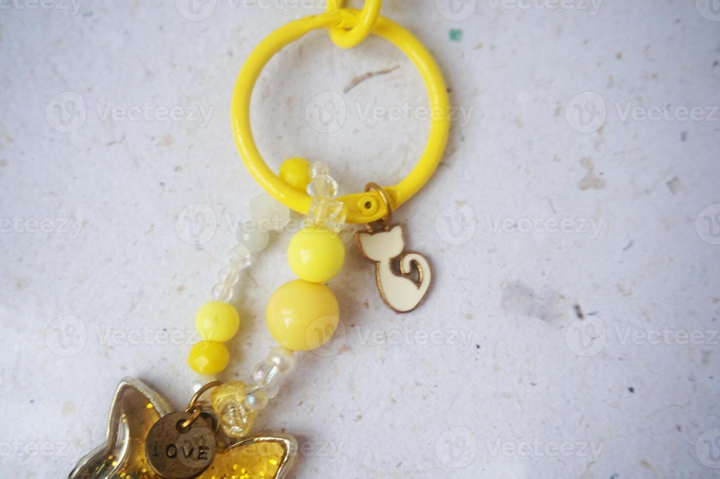 Key chain or bag charm on greyish white background. Top view. photo
