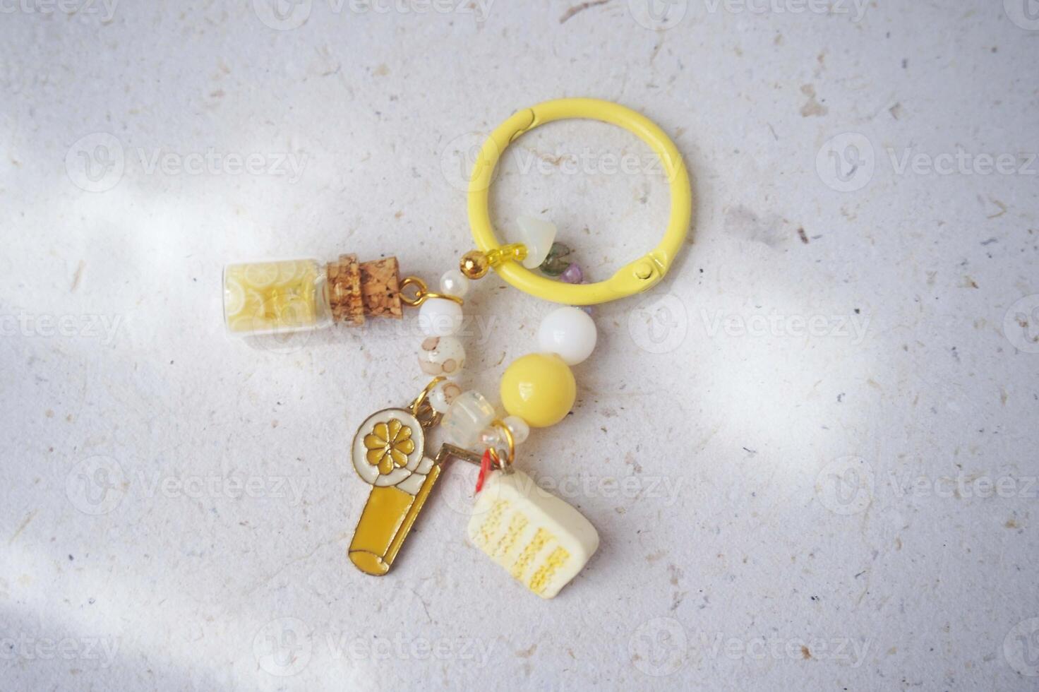 Key chain or bag charm on greyish white background. Top view. photo