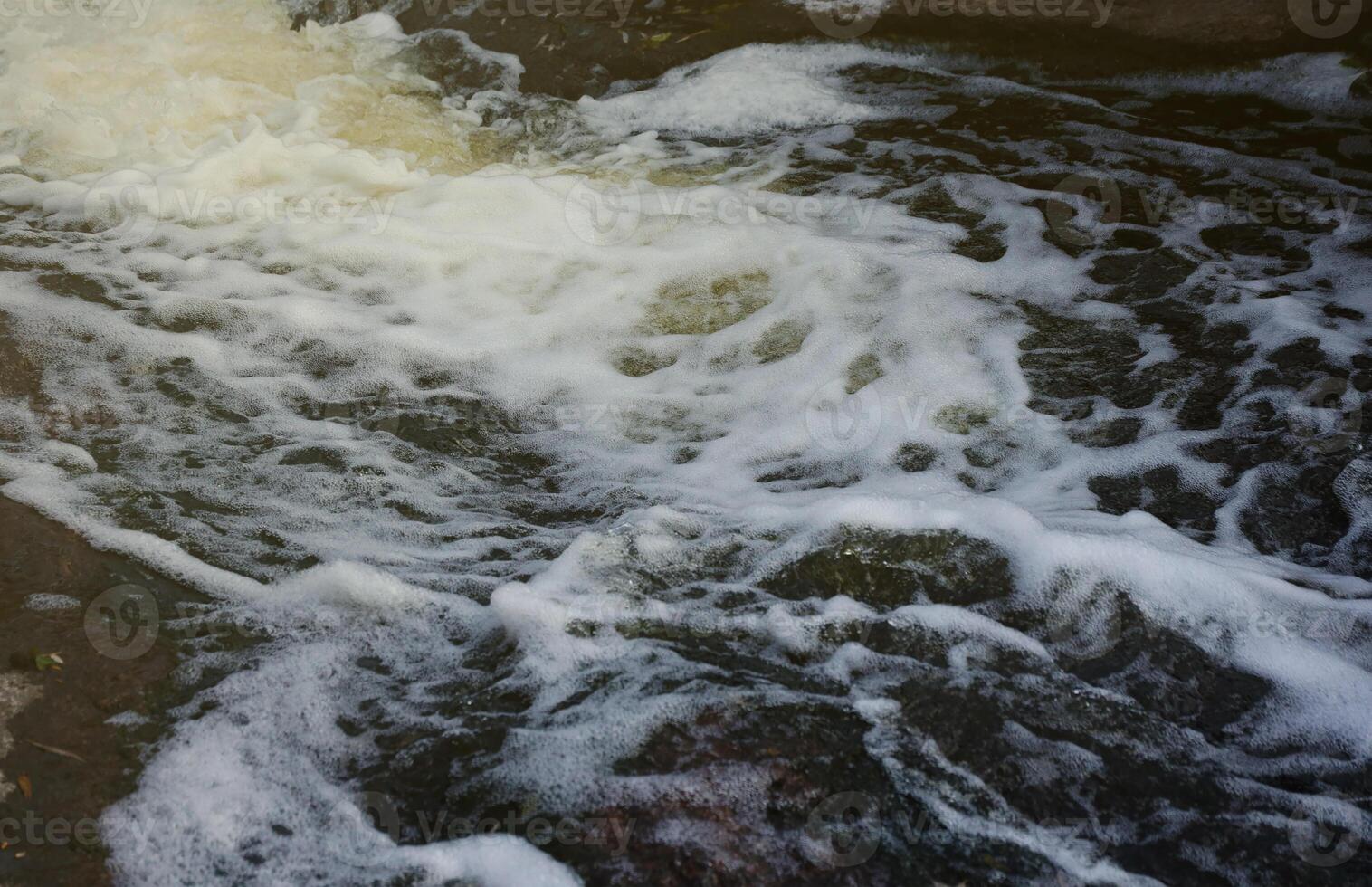 Waves of water of the river and the sea meet each other during high tide and low tide. Deep blue stormy sea water surface with white foam and waves pattern, background photo
