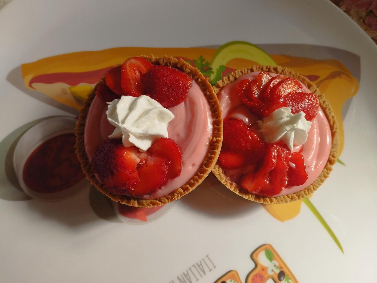 two strawberry cheesecakes are on a plate photo