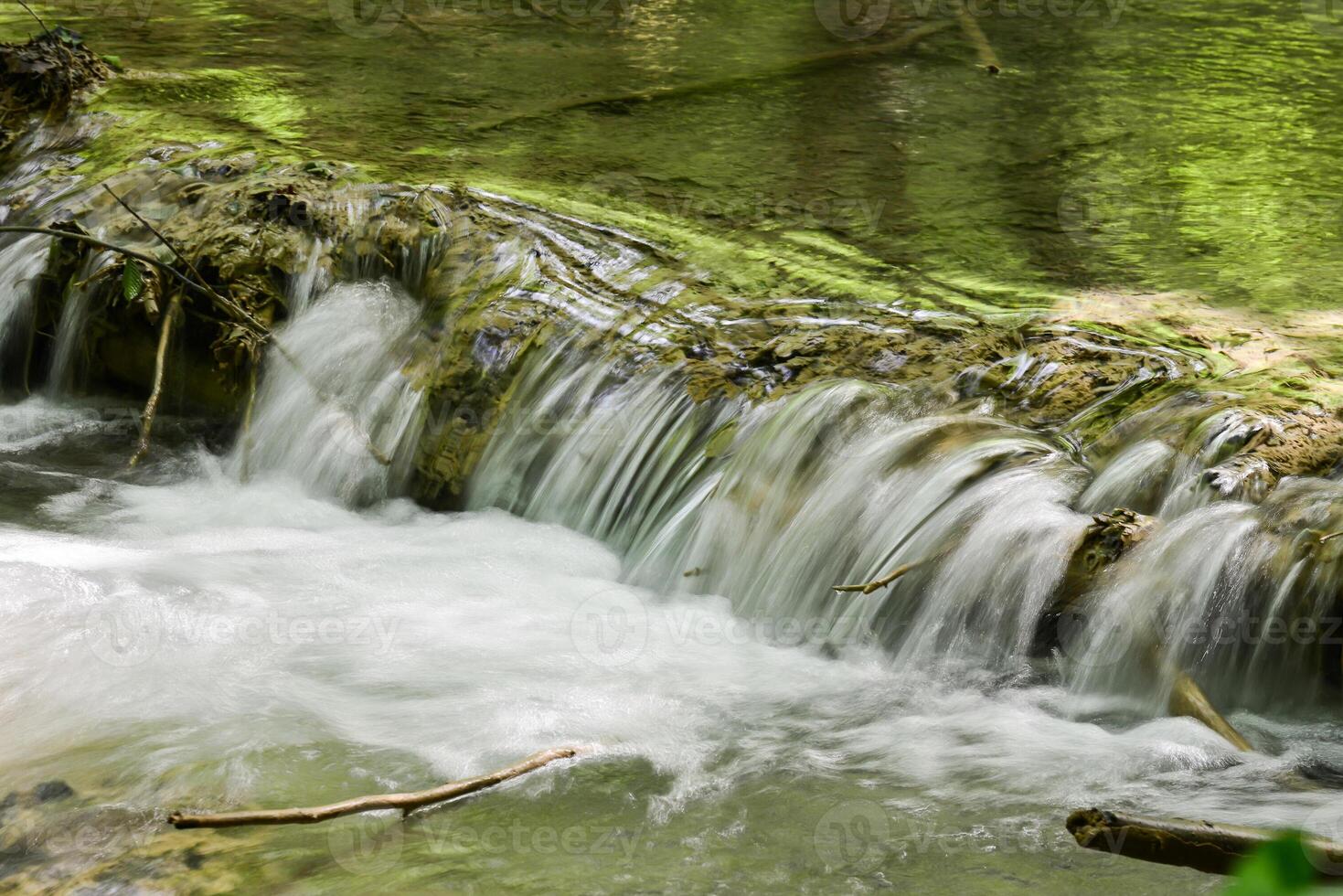 Mountain stream in the forest - long exposure and flowing water photo