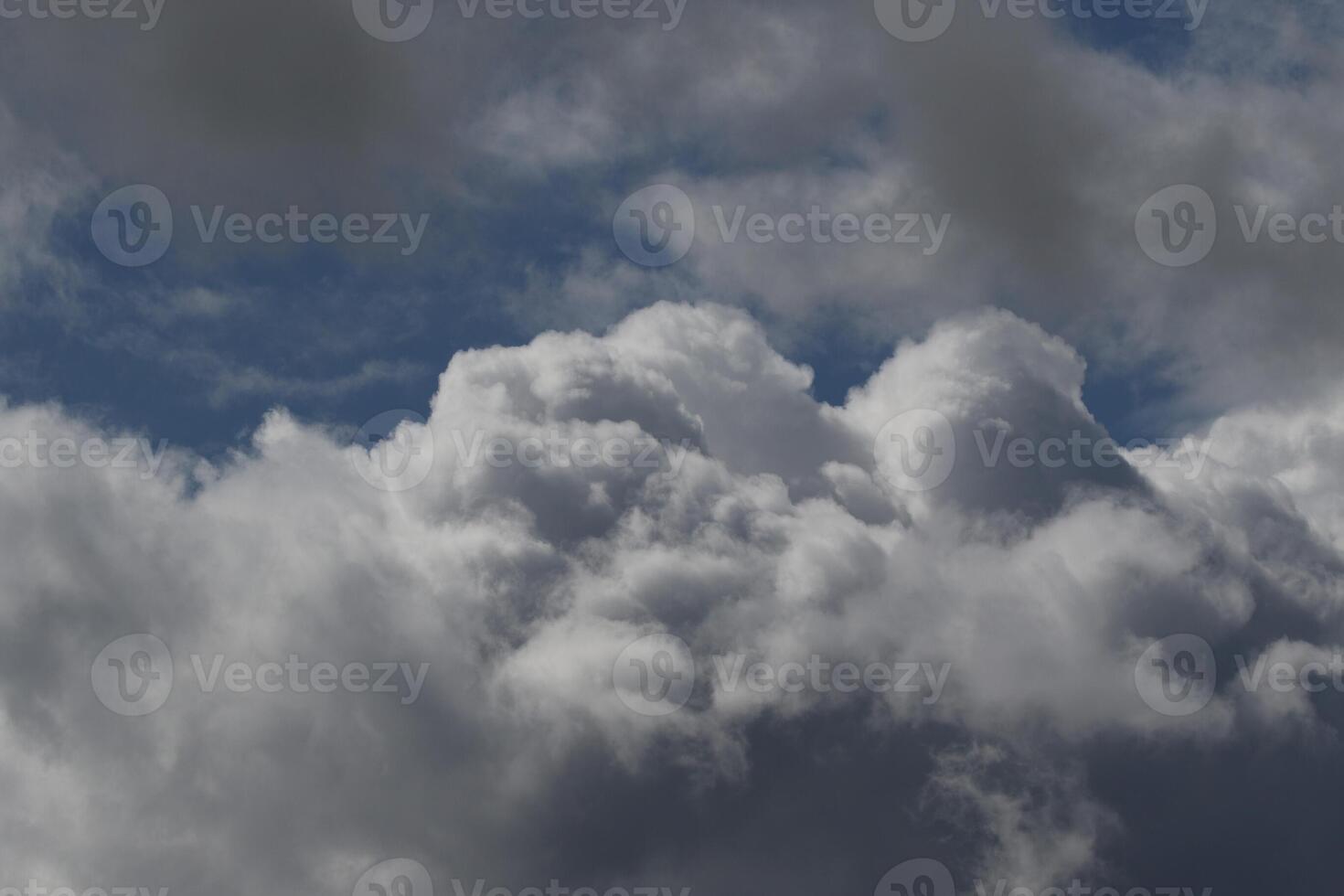 Cloudscape scenery, overcast weather above dark blue sky. Storm clouds floating in a rainy dull day with natural light. White and grey scenic environment background. Nature view. photo